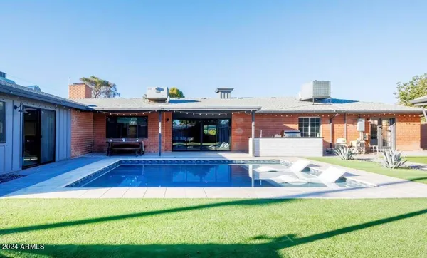 a view of a house with swimming pool and furniture