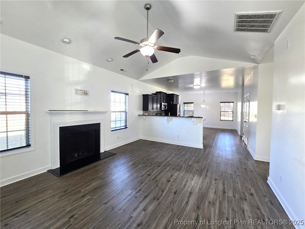 2816 Deepwater Court Fayetteville, NC 28306 - Photo 12 of 34 an empty room with wooden floor a fireplace a ceiling fan and windows