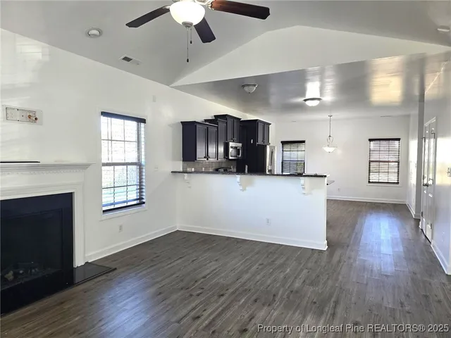 a view of a kitchen with wooden floor and a kitchen space with a sink