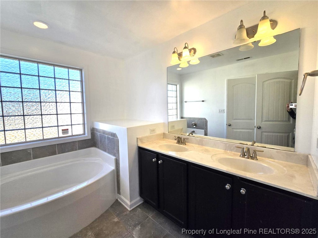 2816 Deepwater Court Fayetteville, NC 28306 - Photo 26 of 34 a bathroom with a tub a sink and a mirror