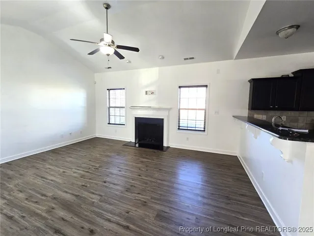 a view of empty room with wooden floor and fireplace