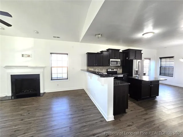 a view of kitchen with microwave refrigerator and cabinets