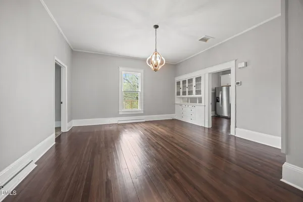 a view of empty room with wooden floor and window
