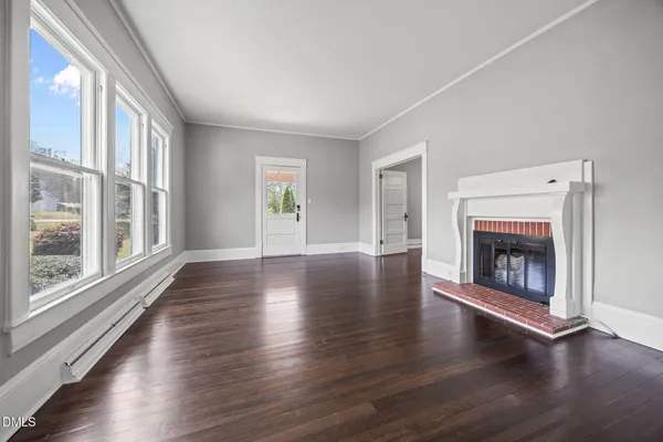 an empty room with floor to ceiling windows and fireplace