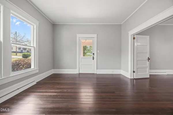 an empty room with wooden floor and fireplace