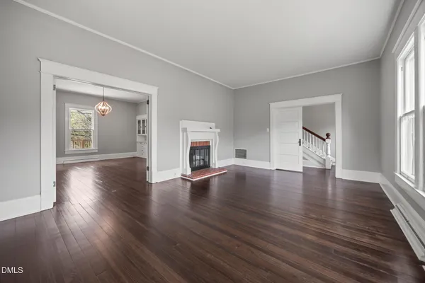 a view of empty room with wooden floor and window