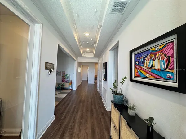 a view of a hallway with wooden floor and closet