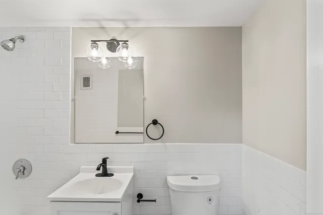a bathroom with a sink a toilet and mirror