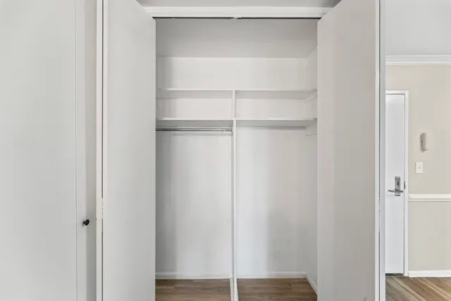 a view of walk in closet with empty racks