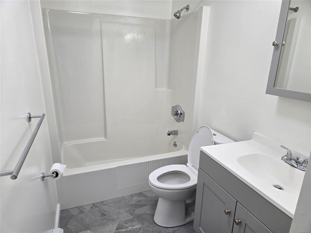 119 Crooked Hill Road, Unit 103 Pearl River, NY 10965 - Photo 10 of 16 Full bathroom featuring tile patterned flooring, vanity, toilet, and washtub / shower combination