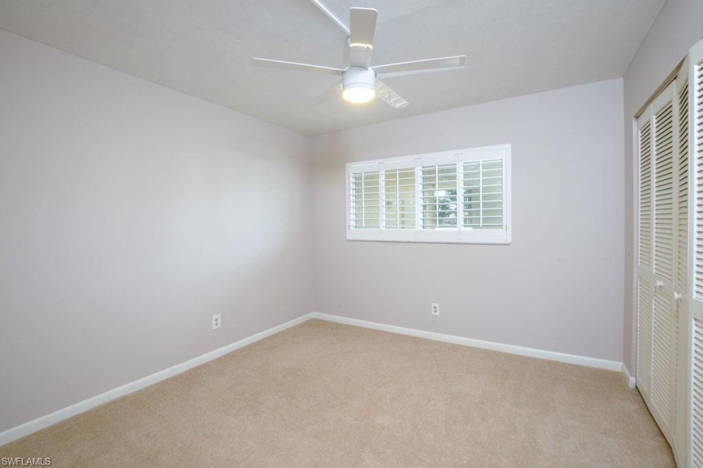 1 High Point Circle West, Unit 203 Naples, FL 34103 - Photo 11 of 31 an empty room with a window and a fan