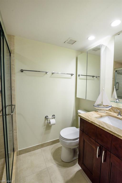 1 High Point Circle West, Unit 203 Naples, FL 34103 - Photo 13 of 31 a bathroom with a granite countertop sink a toilet a mirror and shower