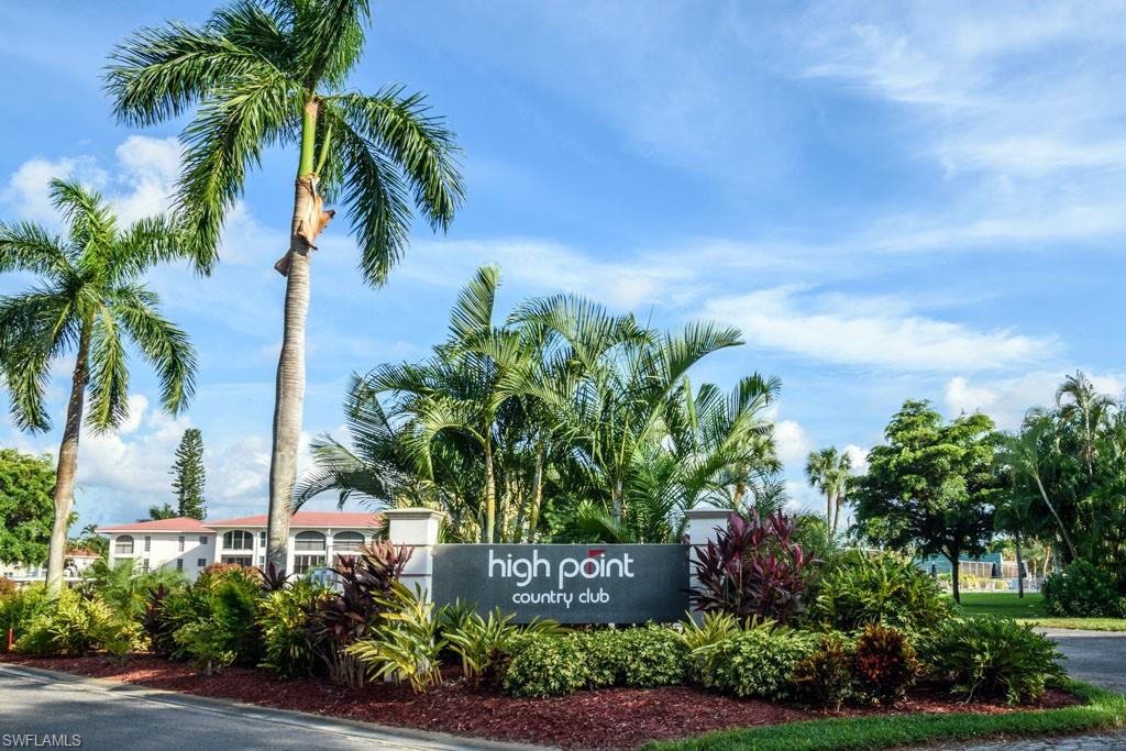 1 High Point Circle West, Unit 203 Naples, FL 34103 - Photo 16 of 31 a front view of multi story residential apartment building with yard and sign board