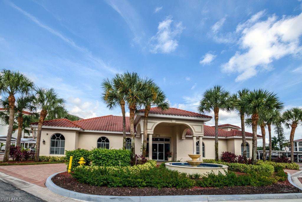 1 High Point Circle West, Unit 203 Naples, FL 34103 - Photo 17 of 31 a front view of a house with a garden