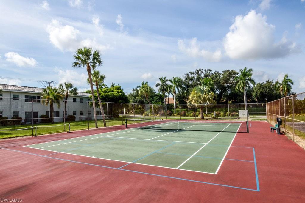 1 High Point Circle West, Unit 203 Naples, FL 34103 - Photo 19 of 31 a view of a tennis ground with large trees