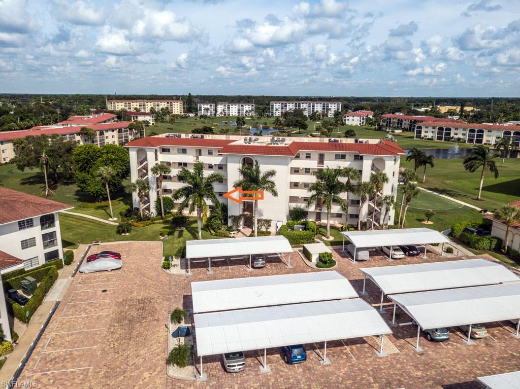 1 High Point Circle West, Unit 203 Naples, FL 34103 - Photo 2 of 31 a picture of a building with a garden and chairs
