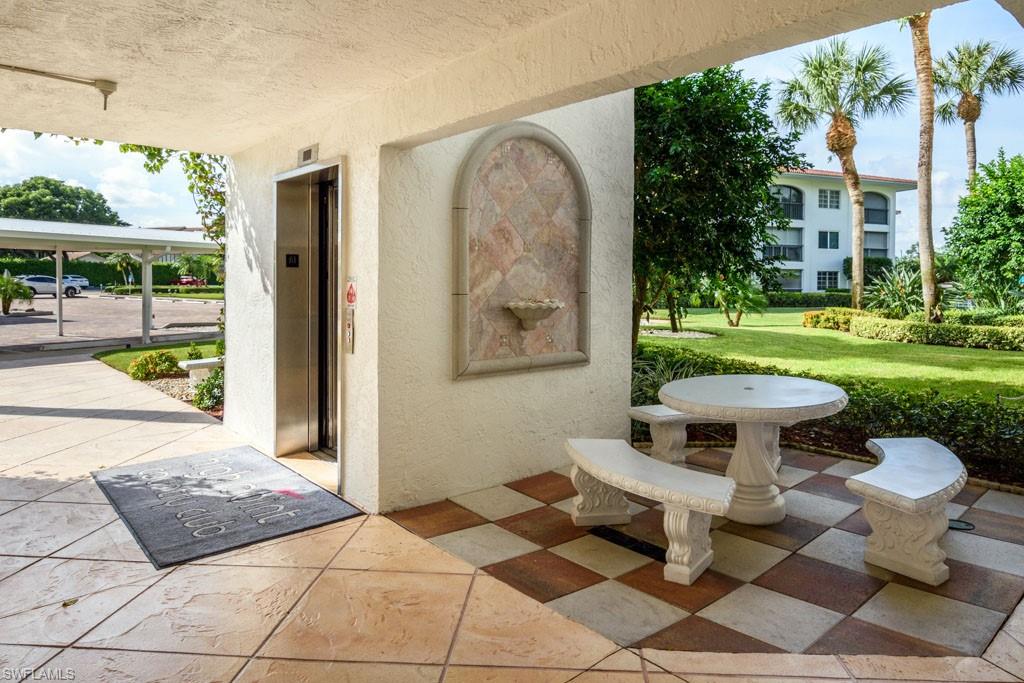 1 High Point Circle West, Unit 203 Naples, FL 34103 - Photo 21 of 31 a view of a patio with couches table and chairs and potted plants