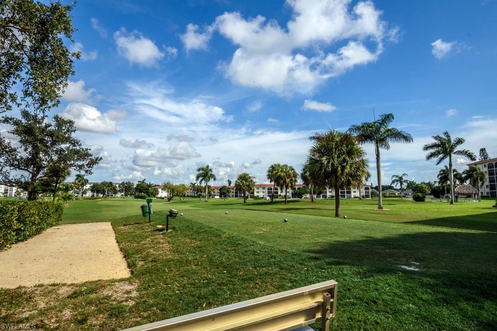 1 High Point Circle West, Unit 203 Naples, FL 34103 - Photo 23 of 31 a view of a golf course with a garden