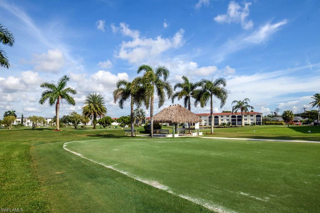 1 High Point Circle West, Unit 203 Naples, FL 34103 - Photo 24 of 31 a view of a grassy field with trees around