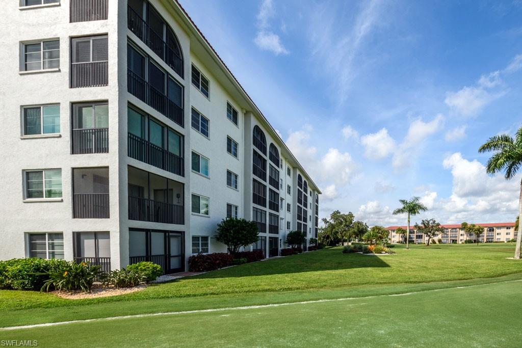 1 High Point Circle West, Unit 203 Naples, FL 34103 - Photo 26 of 31 a front view of a building and yard