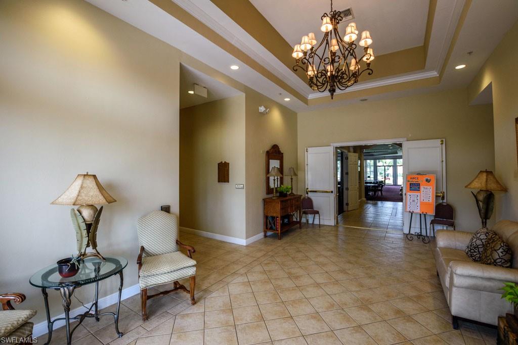 1 High Point Circle West, Unit 203 Naples, FL 34103 - Photo 27 of 31 a living room with furniture and a chandelier
