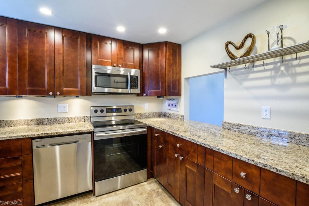 1 High Point Circle West, Unit 203 Naples, FL 34103 - Photo 5 of 31 a kitchen with granite countertop stainless steel appliances and cabinets