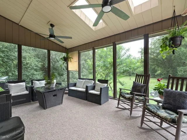 a living room with furniture and a floor to ceiling window