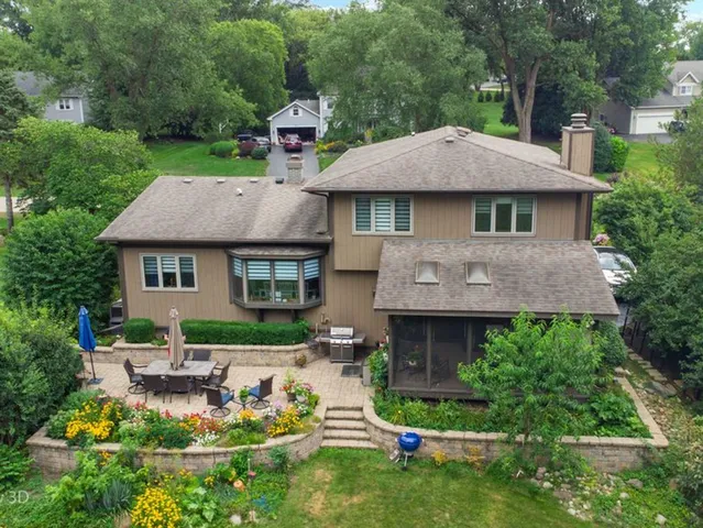 a aerial view of a house with table and chairs in a yard