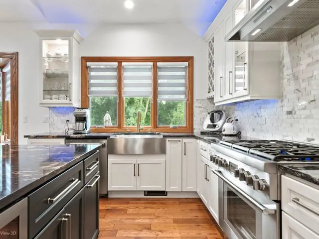 a kitchen with a stove a sink and a granite counter tops