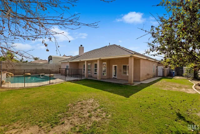 a view of a backyard with couches and swimming pool