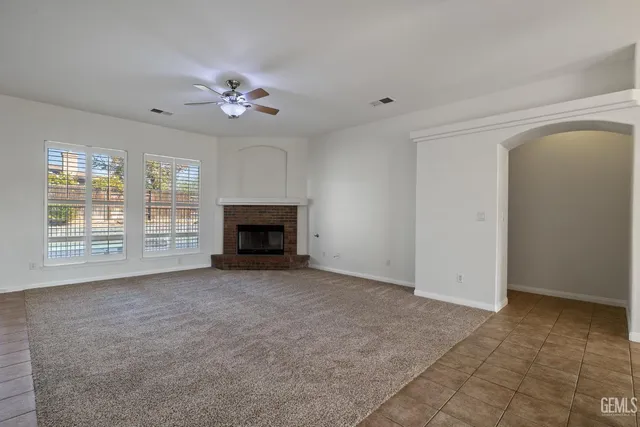 an empty room with windows and fireplace