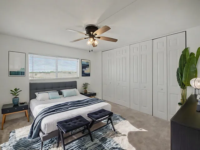 a bedroom with a bed a chandelier and a window