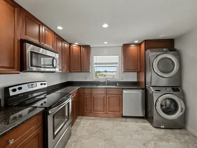 a kitchen with stainless steel appliances granite countertop a sink and a stove top oven