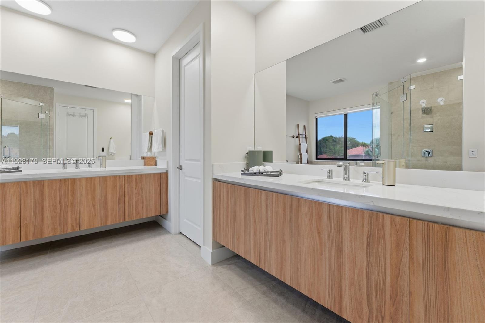 12070 Southwest 83rd Place Miami, FL 33156 - Photo 23 of 42 a bathroom with a double vanity sink a mirror and a bathtub