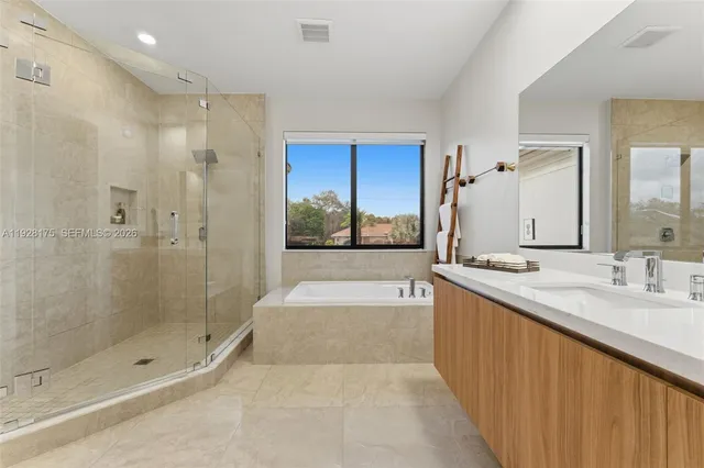 a bathroom with a granite countertop sink a large mirror and shower
