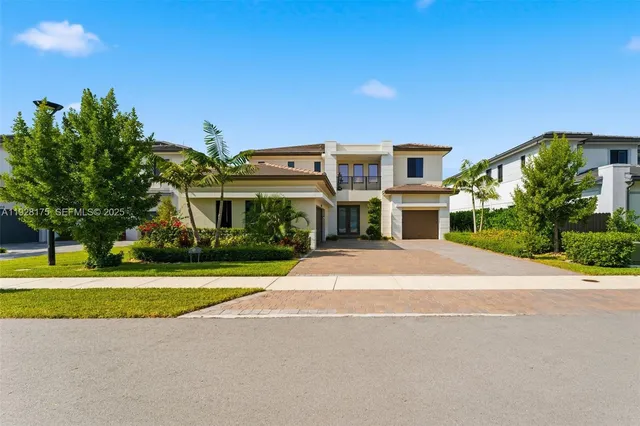 a front view of a house with a yard and potted plants