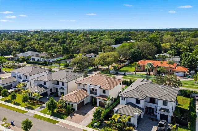 an aerial view of multiple houses with a yard