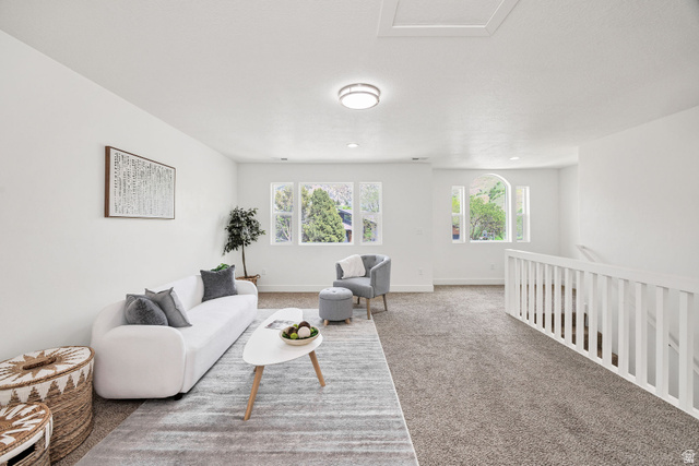 1552 Sumac Drive Logan, UT 84321 - Photo 27 of 72 Spacious upper-level room featuring light gray carpeting, white walls, and a white baluster railing