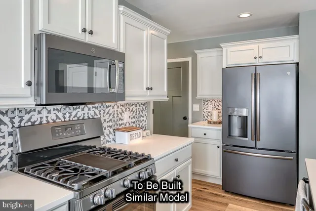 a kitchen with stainless steel appliances granite countertop a stove and a refrigerator