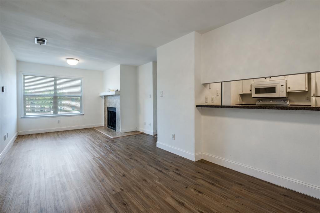 2200 East Trinity Mills Road, Unit 206 Carrollton, TX 75006 - Photo 5 of 24 wooden floor in an empty room with a window