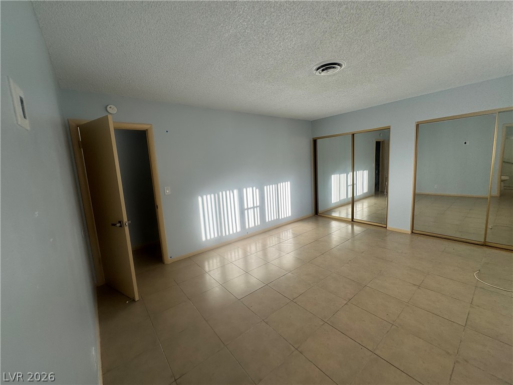 4420 Del Monte Avenue, Unit RENTAL Las Vegas, NV 89102 - Photo 15 of 20 A generously sized bedroom with ample storage provided by mirrored closet doors and durable tile flooring.