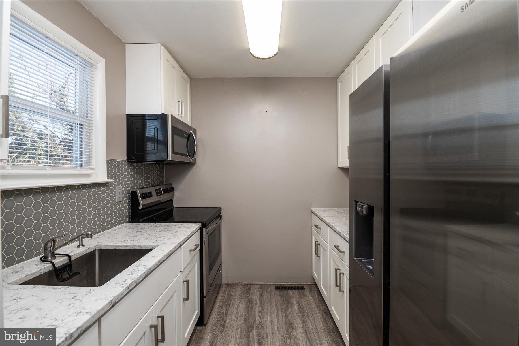 45 Clipper Road Essex, MD 21221 - Photo 14 of 36 a kitchen with a sink a stove and a refrigerator