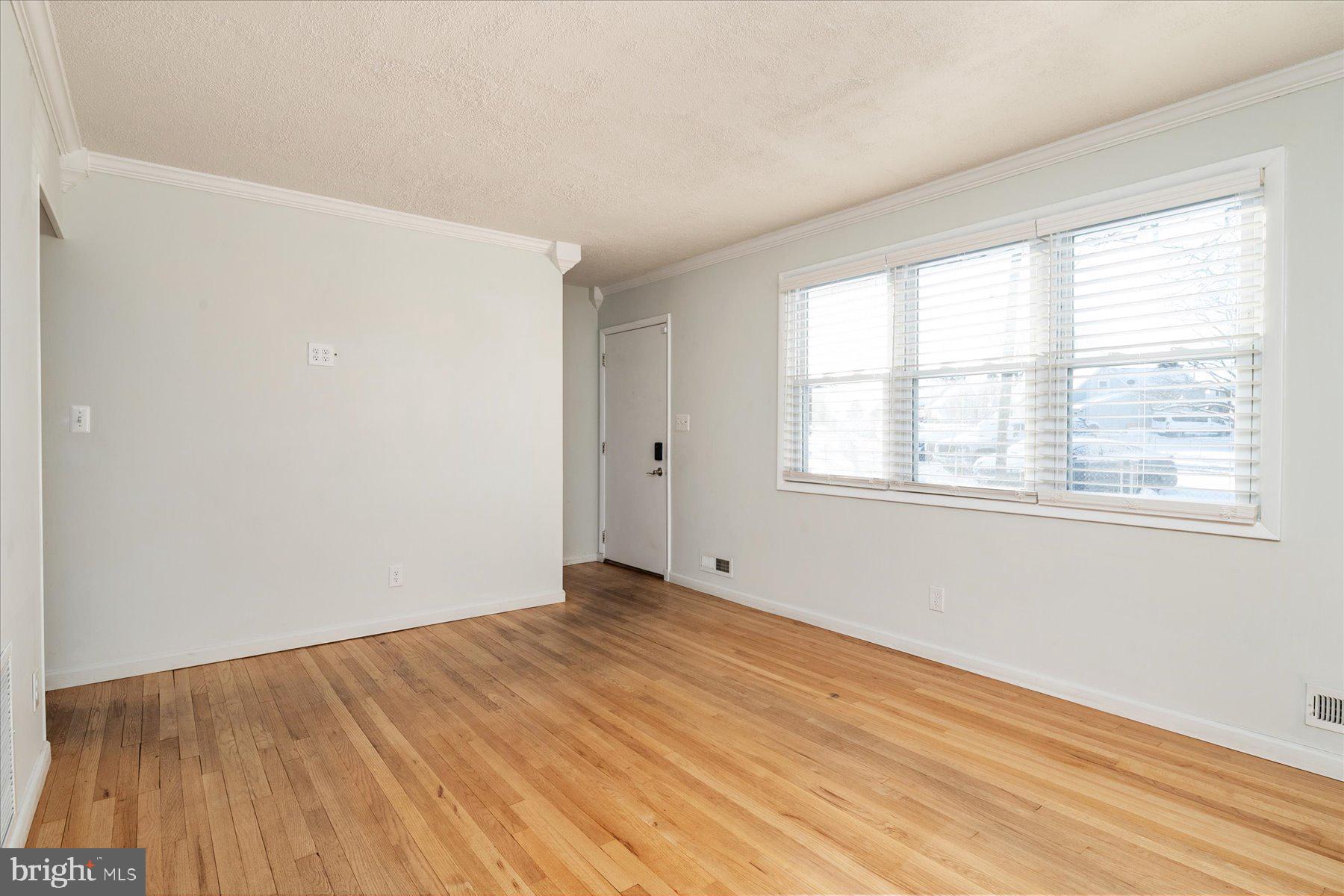 45 Clipper Road Essex, MD 21221 - Photo 6 of 36 a view of an empty room with wooden floor and a window