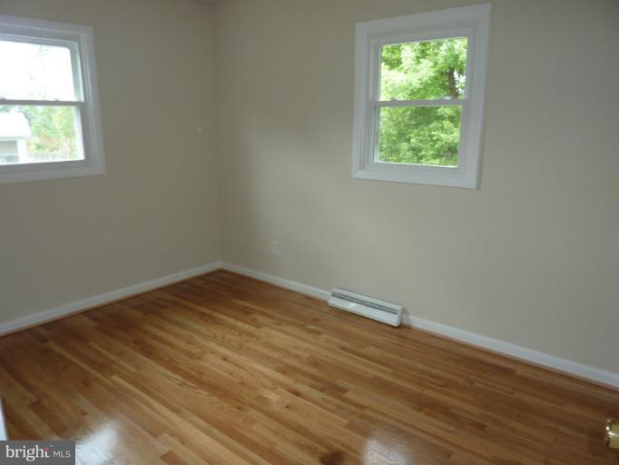 123 Little Whim Road Fredericksburg, VA 22405 - Photo 13 of 17 an empty room with wooden floor and windows