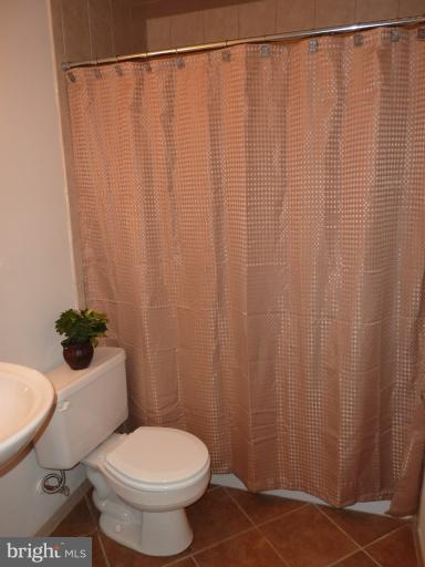 123 Little Whim Road Fredericksburg, VA 22405 - Photo 14 of 17 a white toilet sitting next to a shower curtain