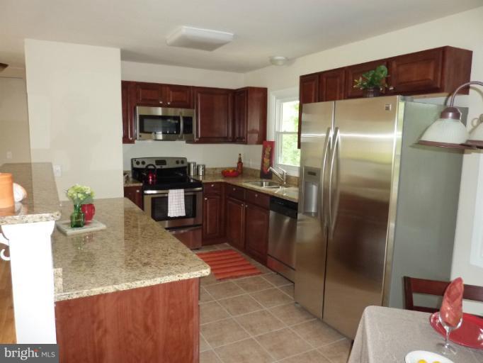 123 Little Whim Road Fredericksburg, VA 22405 - Photo 3 of 17 a kitchen with stainless steel appliances granite countertop a sink stove and refrigerator
