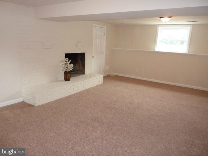 123 Little Whim Road Fredericksburg, VA 22405 - Photo 8 of 17 an empty room with a fireplace and window