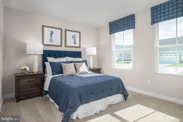 a bedroom with a bed windows and a lamp