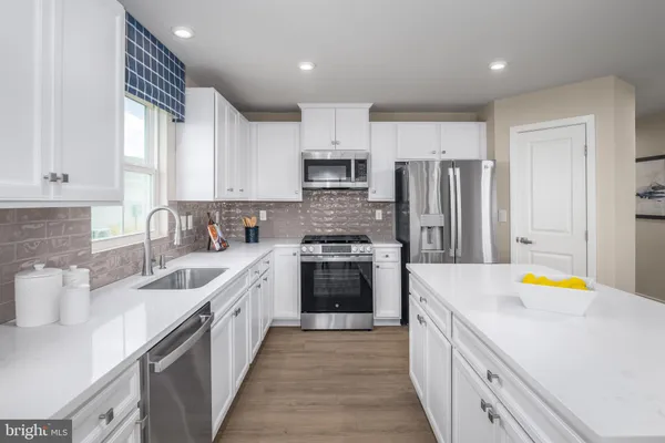 a kitchen with stainless steel appliances a stove sink and cabinets