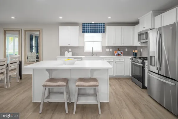 a kitchen with a sink stove cabinets and wooden floor